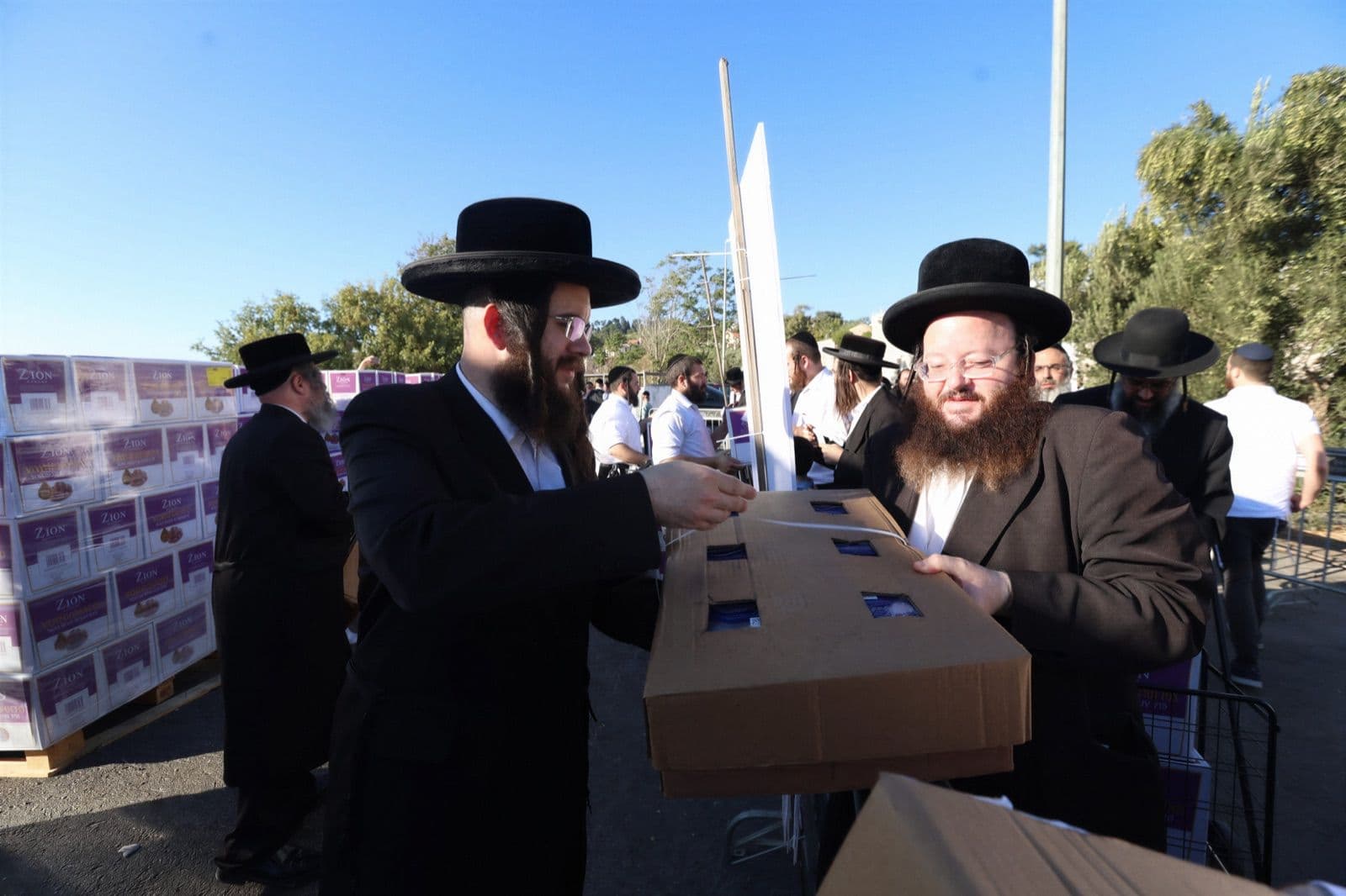 A case of wine handed across the barrier for a simcha